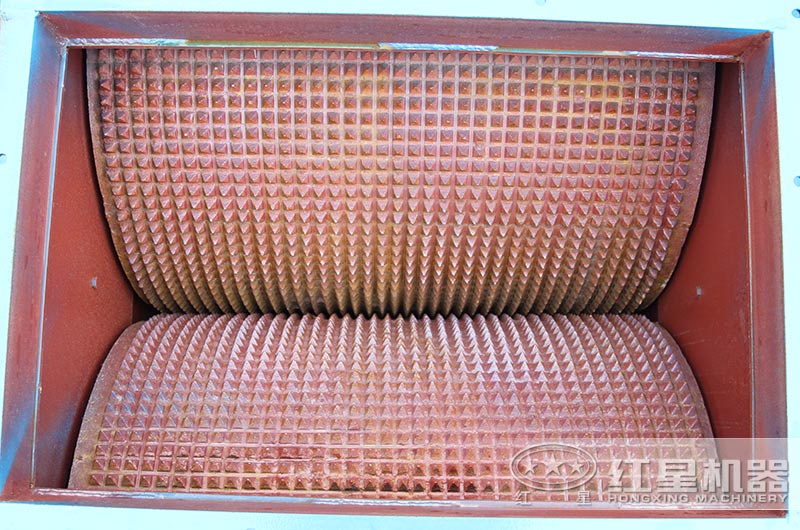 相向轉(zhuǎn)動的兩輥子，調(diào)節(jié)其間隙可改變出料